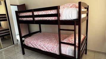 Una cama litera con dos niveles, cada uno con una colcha estampada.