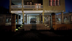 A two-story house with a balcony, a gated entrance, and a car parked inside. - Baja Vacation Home with Solar, WiFi and AC (Vega Baja)