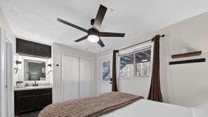 A bedroom with a bed, a ceiling fan, a window with curtains, a bedside table, and a built-in wardrobe. - Ski-In/Ski-Out on Chair 8 | Cozy Condo Sleeps 6 (Brian Head)