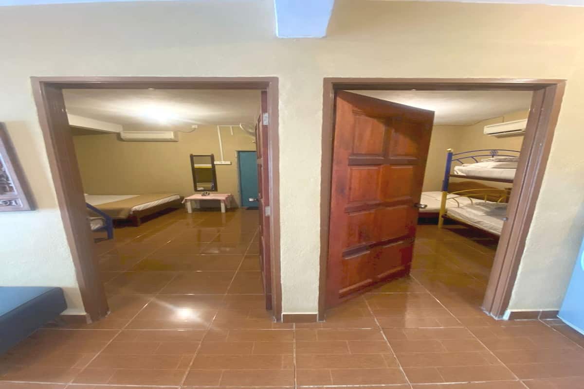 Ein Zimmer mit einem Etagenbett, einem kleinen Tisch und einem Spiegel an der Wand.