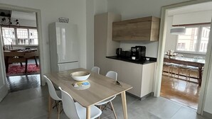 Une cuisine moderne avec une table à manger, des chaises et un luminaire suspendu.