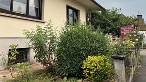 Un bâtiment à la façade beige, aux fenêtres à encadrement noir et sur lequel on peut lire une enseigne indiquant qu’il s’agit d’une cave à vin.