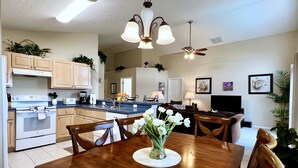 A spacious kitchen with wooden cabinets, a central island, and a dining area with a wooden table and chairs.