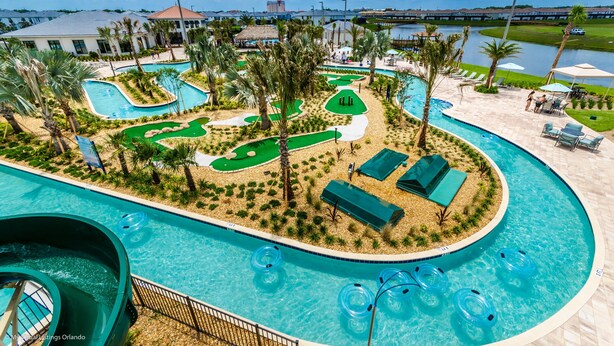 Ein Poolbereich mit Wasserrutsche, mehreren Pools und einem Golfplatz.