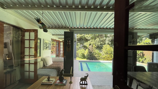 Una sala de estar acogedora con una mesa de centro de madera, un sofá y vista a una piscina.