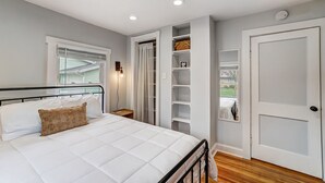 Un dormitorio con cama, armario y puerta que da a un balcón.