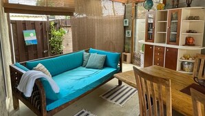 Une pièce chaleureuse avec un canapé bleu, une table à manger en bois et un meuble avec des étagères.