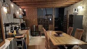 Une cuisine chaleureuse avec une table et des chaises en bois, une cuisinière encastrée et un réfrigérateur.