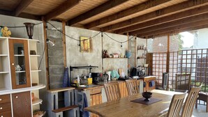 Une cuisine rustique avec des poutres en bois, une table à manger avec des chaises et un meuble encastré.