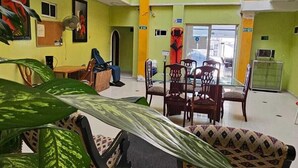 A spacious indoor area with a high ceiling, multiple levels, and a central open space with chairs and tables. - Hotel Barranquilla Inn (Barranquilla)