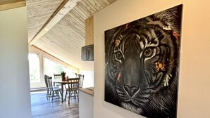 Un corridoio con soffitto in legno e un quadro che raffigura il volto di una tigre.