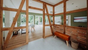 Une pièce spacieuse avec des poutres apparentes, un mur en briques et un banc.