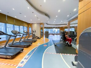 Uma academia com esteiras, elípticos e equipamentos de musculação.