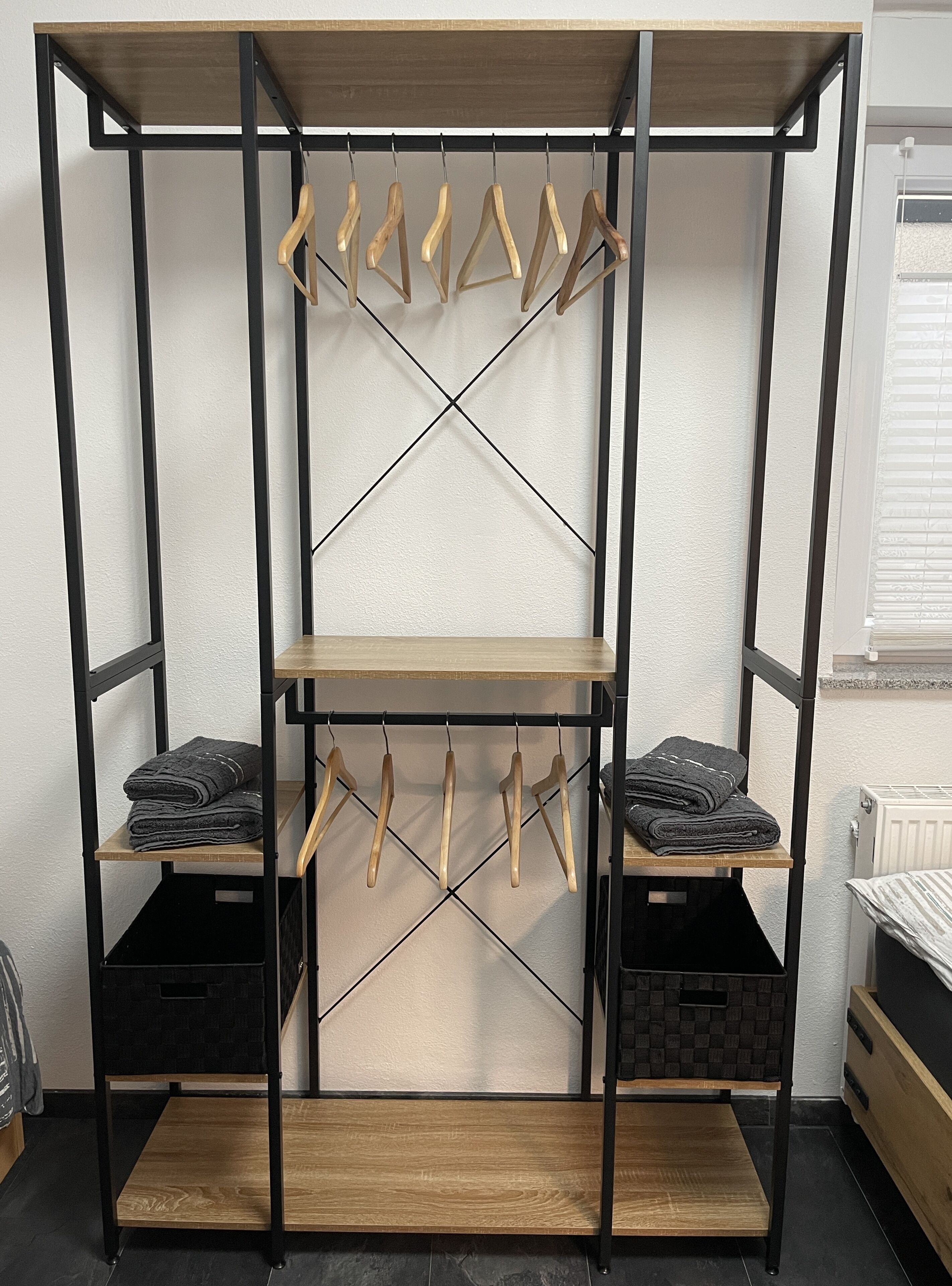 Une armoire métallique à plusieurs niveaux, dotée d’étagères et de supports en bois, ainsi que d’un bureau rabattable et de tiroirs de rangement.