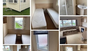 A caravan with a kitchenette, two beds, a bathroom with a shower, and a small dining area. - Beach Daze - Silver Beach - Standard (Skegness)