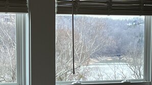A window with a view of a wooden deck and a house in the background. - FAMILY LAKE ESCAPE AWAITS. Walk to Boat Ramp. Sleeps 12, with plenty of parking (Bronston)