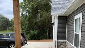A house with a stone pillar, a garden with pebbles and plants, and a parked car. - FAMILY LAKE ESCAPE AWAITS. Walk to Boat Ramp. Sleeps 12, with plenty of parking (Bronston)