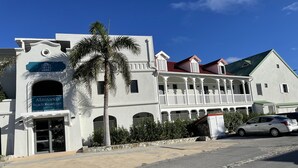 A two-story building with a sign reading "Alamanda Beach Residence." - Bella Vista 2 bedroom - Orient Bay (Collectivité de Saint-Martin)