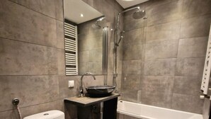 A modern bathroom with a toilet, sink, and bathtub. - Beautiful place in the city center (Kraków)