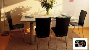A dining area with a table set for four, surrounded by chairs, a vase with flowers, and framed pictures on the wall. - Hotspot Venice Ca Marcello 2000 Palace (Venezia)