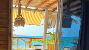 A room with a bed, a view of the beach, and a wooden ceiling. - Mio Mio Beach (Cartagena)
