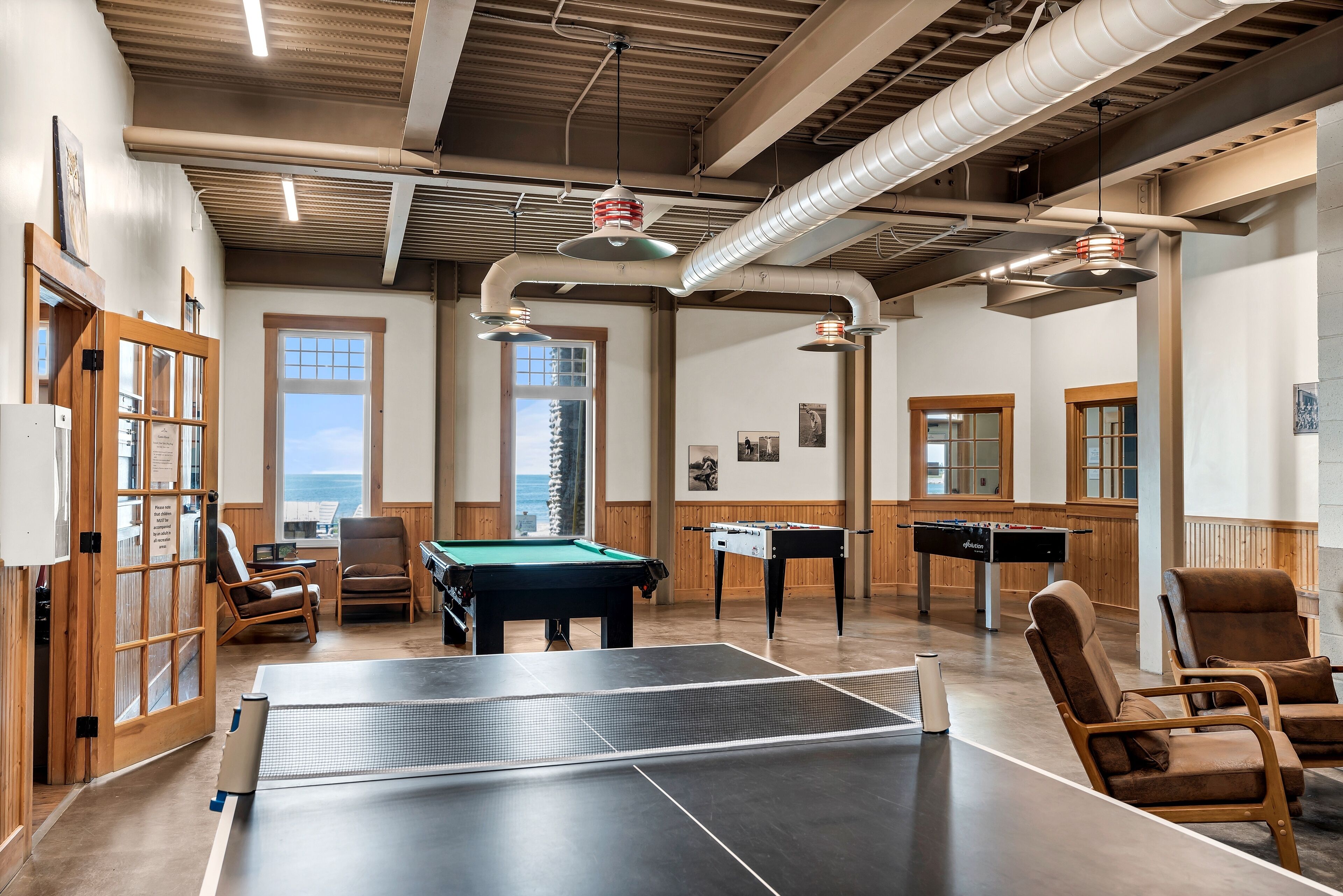 Zona interior àmplia de lleure amb taula de ping-pong, taula de bitlles i taula de futbolí.