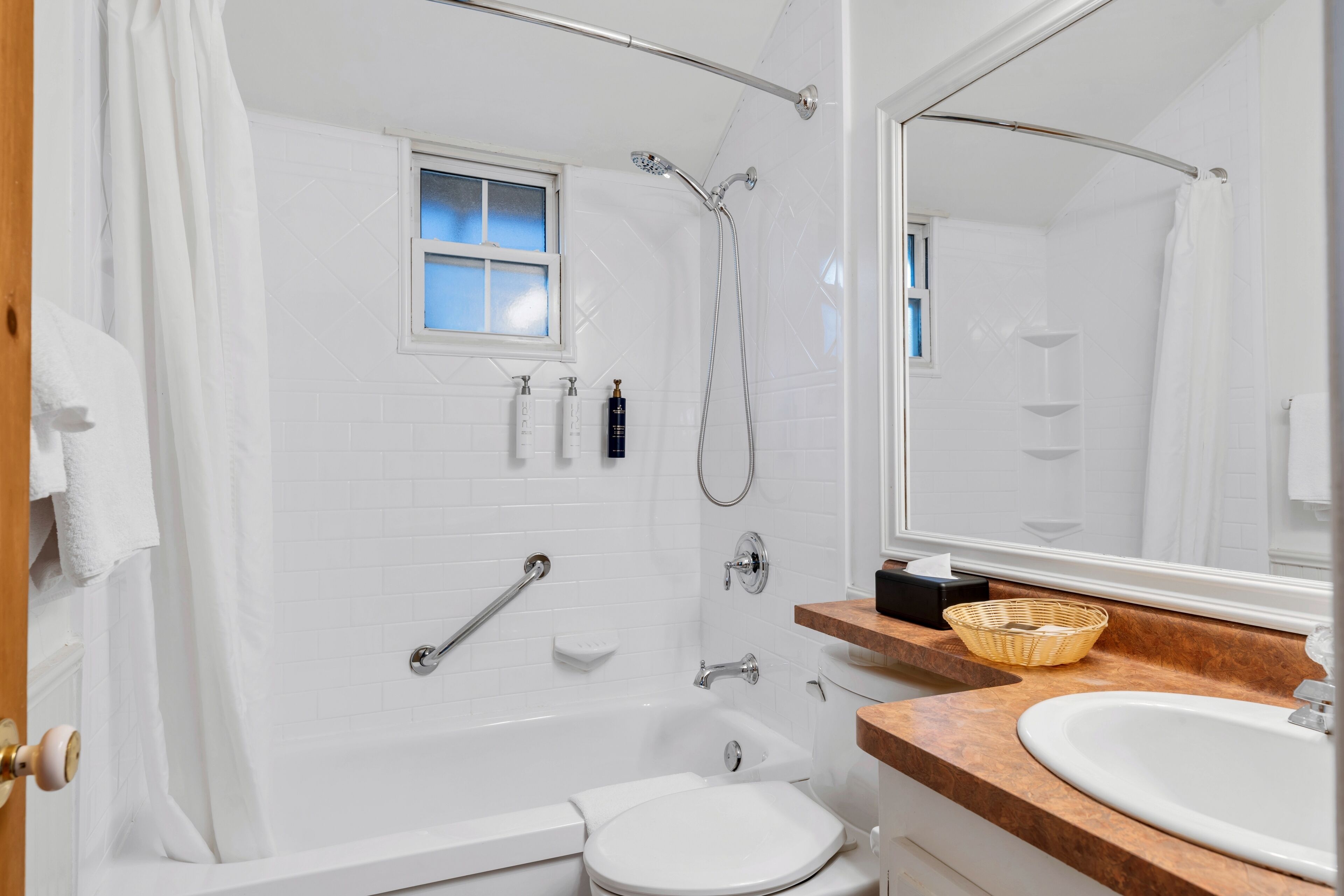 A modern bathroom with a bathtub, toilet, and sink.
