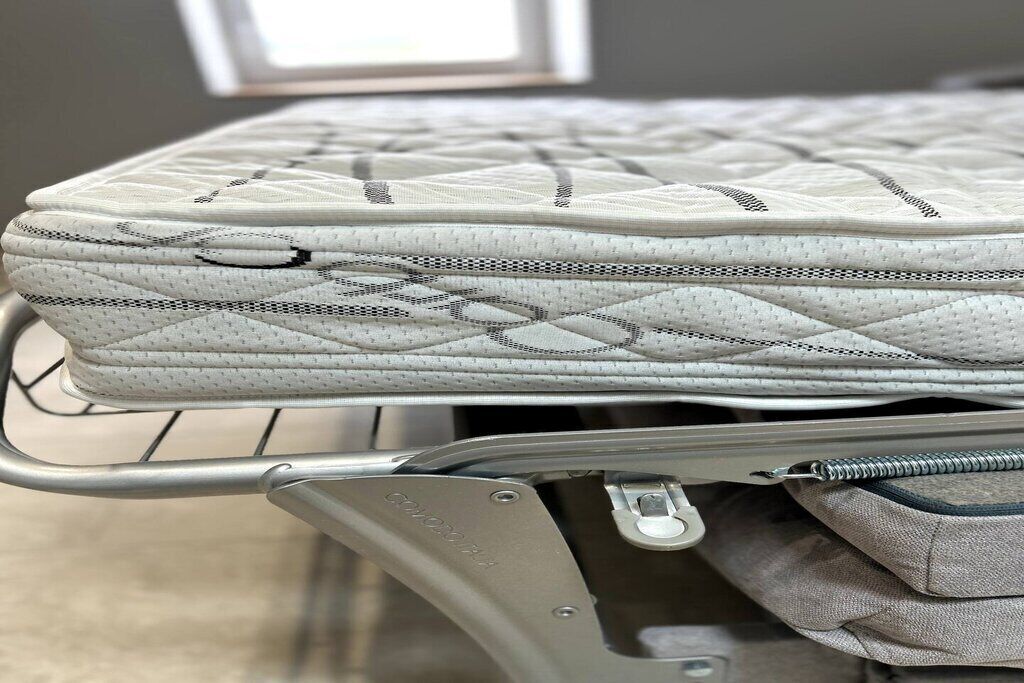 A mattress in a metal cart, likely in a hotel room.