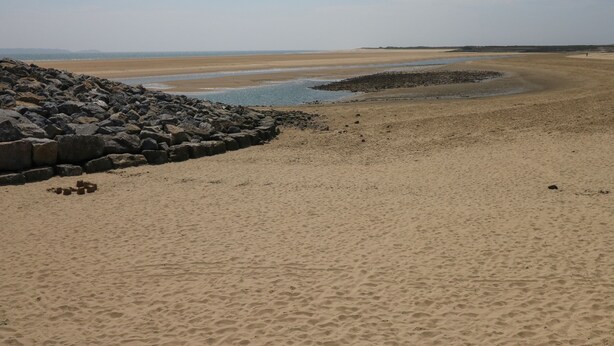 A beach with a rocky shoreline and a sandy beach area. - Sŵn Y Môr (Burry Port)