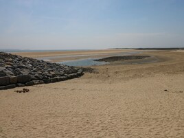 A beach with a rocky shoreline and a sandy beach area.