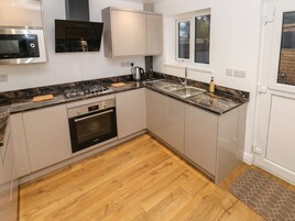 A modern kitchen with a Bosch oven, a microwave, a gas stove, and a window above the sink.