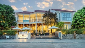A two-story hotel with a balcony, outdoor seating, and a sign reading "Fuji Moon Apartments." - Full Moon Apartments (Da Nang)