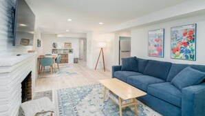 Un salon moderne avec une cheminée, un canapé bleu et une table basse en bois.