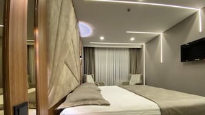 A modern hotel room with a large bed, a wooden nightstand, a flat-screen TV mounted on the wall, and a ceiling with recessed lighting. - Beşiktaş Vip İnn Hotel & Suites (Istanbul)