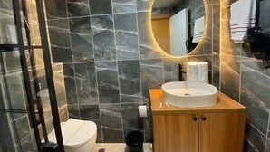 A modern bathroom with a marble backsplash, a wooden vanity, a white sink, and a glass shower enclosure. - Beşiktaş Vip İnn Hotel & Suites (Istanbul)