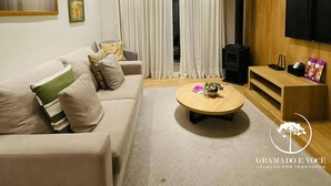Una sala de estar moderna con un sofá, una mesita de centro y un televisor.