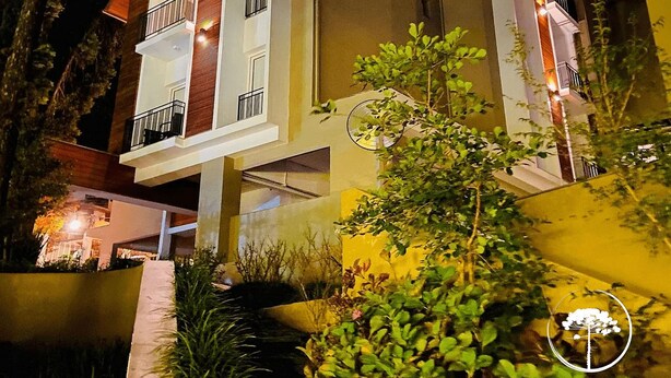 A multi-story hotel with balconies and a well-lit facade. - Apartamento Novo Loft One Centro Gramado (Gramado)