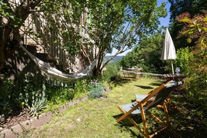 Un hamac, une chaise et une table dans un jardin avec vue.