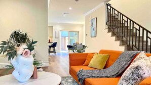 A living room with an orange sofa, a round coffee table, and a decorative vase. - Jie’s Choice - Sweet Home in Pasadena.

 (Pasadena)
