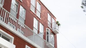 Un edificio de varios pisos con barandillas y balcones blancos.