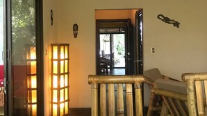 Una habitación con una mesa de madera, un banco y una puerta de vidrio que da al exterior.