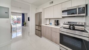 A modern kitchen with stainless steel appliances, light wood cabinets, and a large window. - Wynwood Charm 1, Live the art.1 Free Gated Parking (Miami)