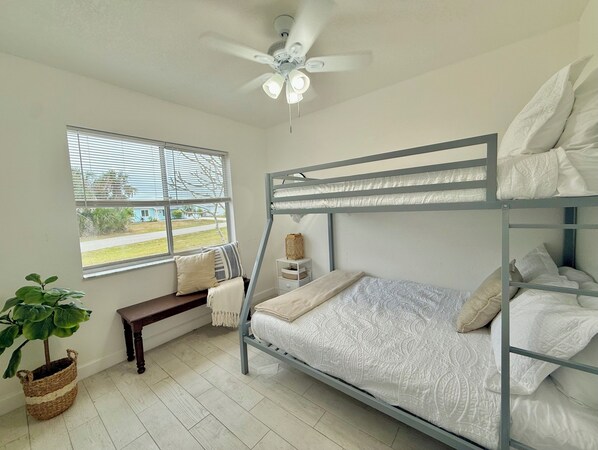 A bunk bed room with a ceiling fan, a window with blinds, a bench, and a potted plant. - Ellie’s Landing 3 – Cozy Lanai Retreat w/ Heated Pool (Port Charlotte)