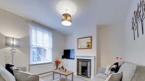 A modern living room with a fireplace, a television, and two sofas. - Pass the Keys | Modern and Spacious Terrace in Central Cambridge (Cambridge)