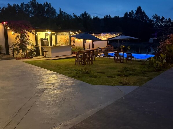 An outdoor patio area with a pool, seating, and a bar. - DPJ Hotel (Valle de Bravo)