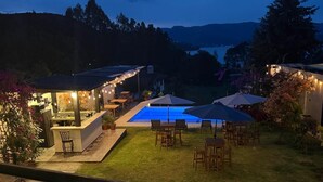 Ein Garten mit Pool, Sitzgelegenheiten im Freien und einer Bar.