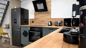 Eine moderne Küche mit Holzarbeitsplatte, Edelstahlgeräten und einem eingebauten Backofen.