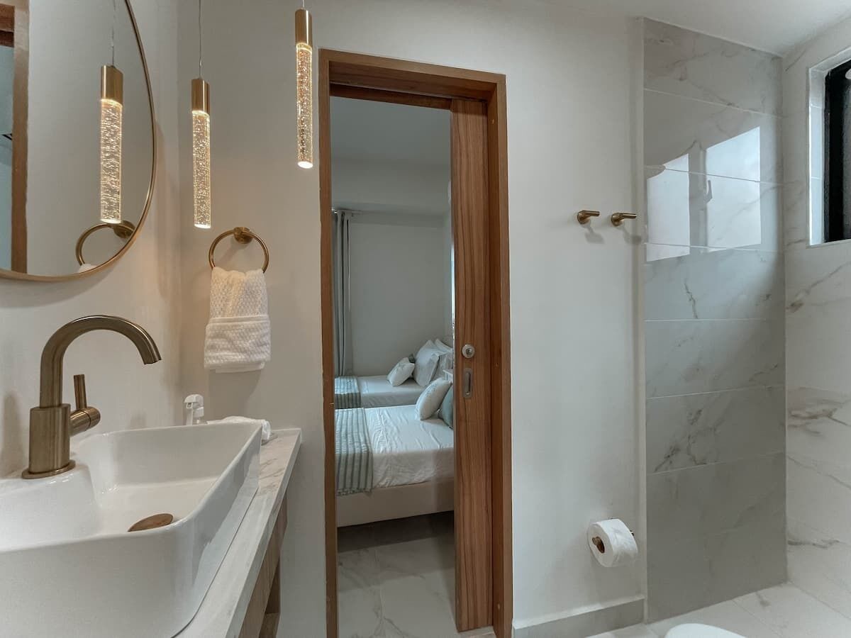 Een moderne badkamer met een witte wasbak, een spiegel en een douche.