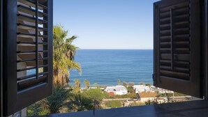 A view through open shutters of a coastal area with palm trees and buildings in the background. - Gorgeous Villa with outbuilding for a relaxing vacation (Torre Colonna-Sperone)