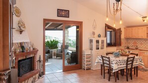 A kitchen with a dining area, a fireplace, and a view of the outdoors. - Gorgeous Villa with outbuilding for a relaxing vacation (Torre Colonna-Sperone)